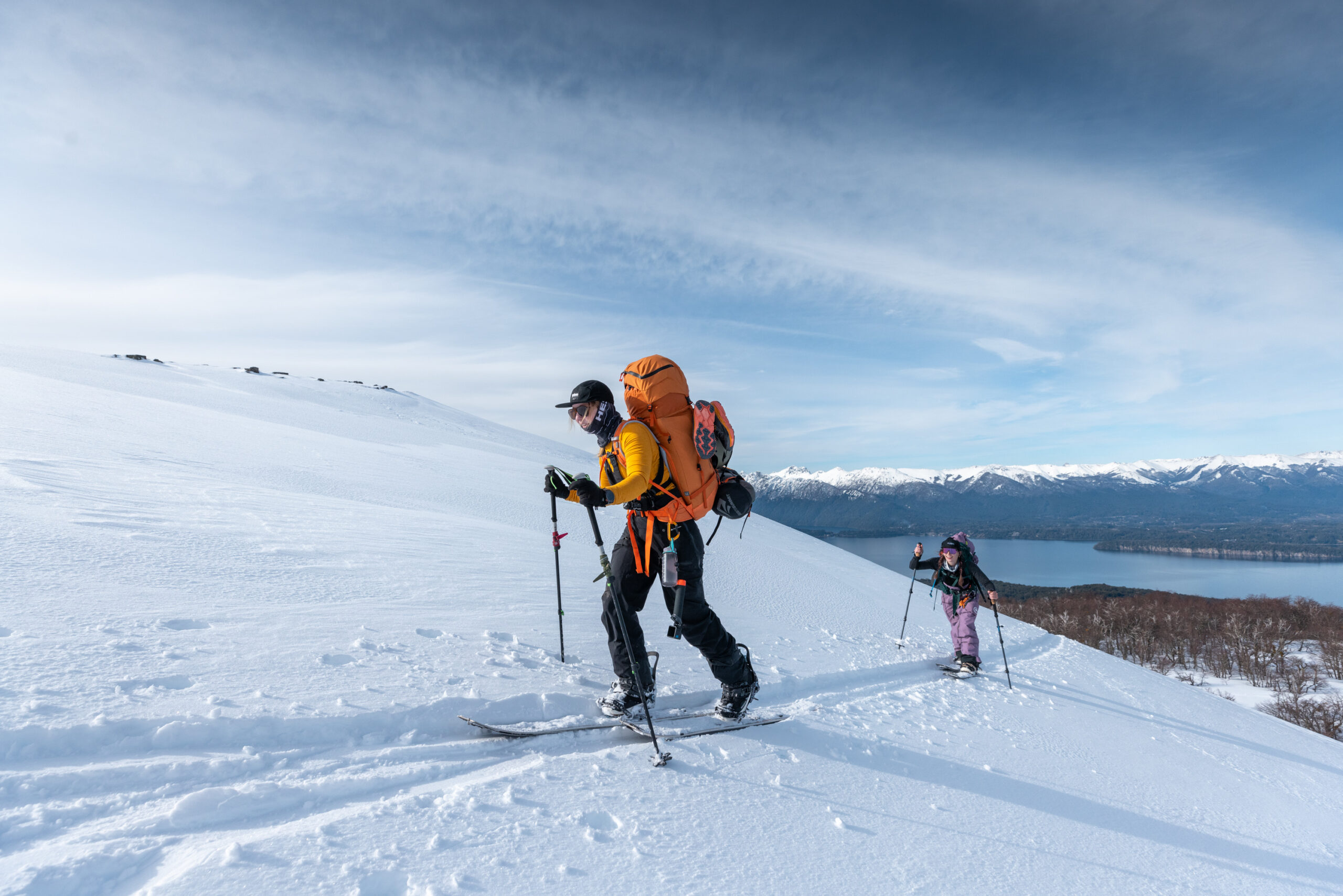 Female splitboarder hiking through snow-covered Andes during LUX Snow retreat