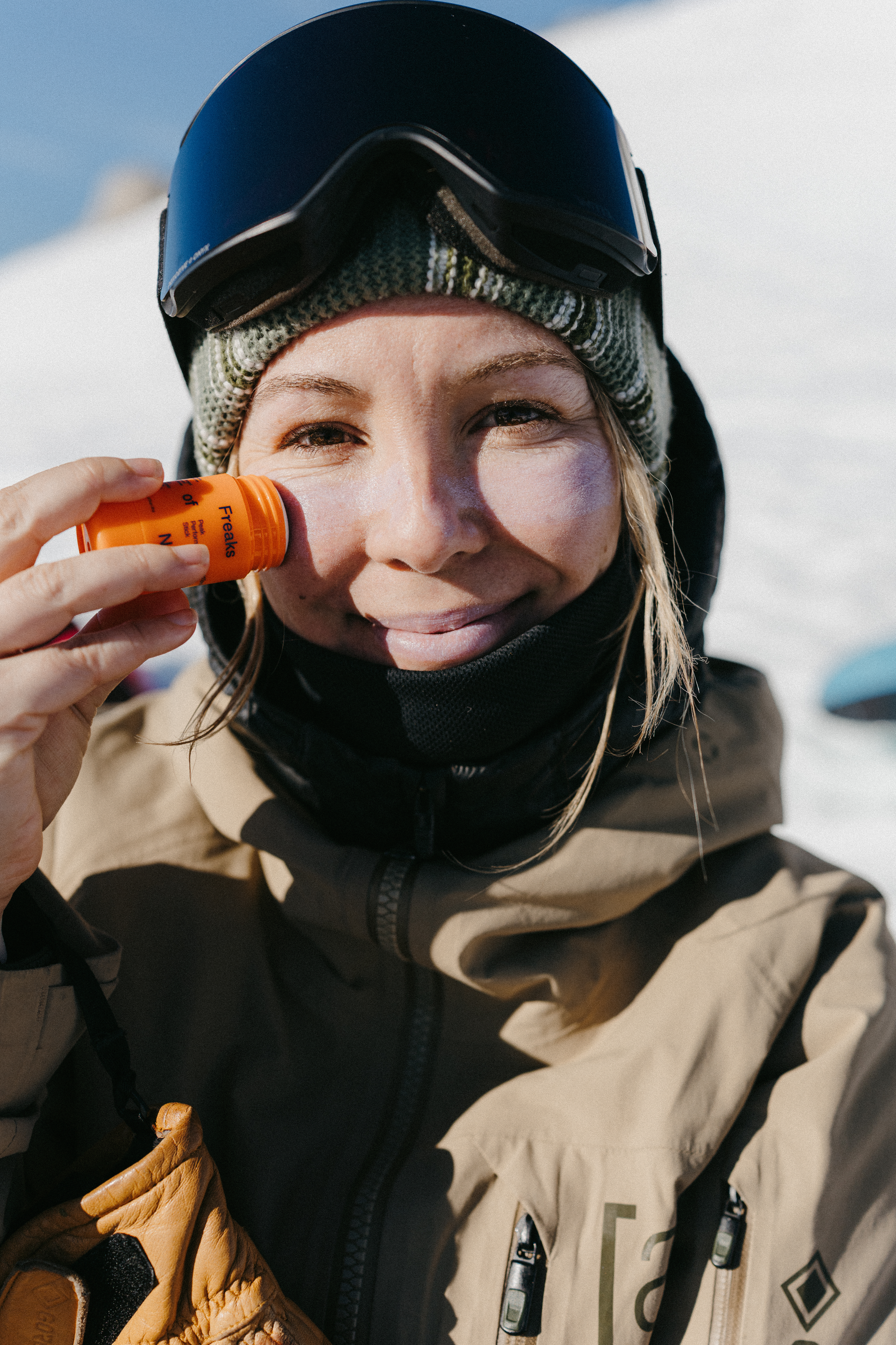 snowboarder applying sunscreen
